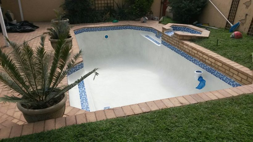 Finished pool with fresh marbelite and mosaic trim, ready to fill