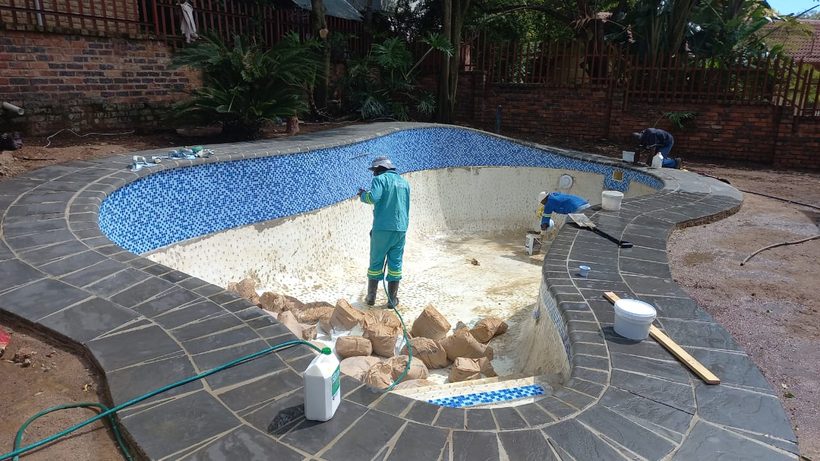 The Blue Storm Pools team relining the pool, with new mosaic waterline and slate coping laid
